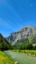 Power lines over the Saalach River in the Alpine Mountains Royalty Free Stock Photo