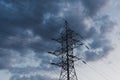 Power transmission line pole against dark blue cloudy sky. Royalty Free Stock Photo