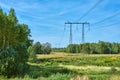 Power transmission line support against the background of a field and forest Royalty Free Stock Photo