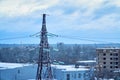 Power transmission line tower against blue sky and clouds with snow-covered high-voltage insulators Royalty Free Stock Photo