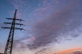 Power transmission pylon against the sky with orange and dark clouds Royalty Free Stock Photo