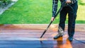 power washing - man cleaning terrace with a power washer - high water pressure cleaner on wooden terrace surface Royalty Free Stock Photo