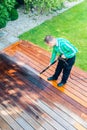 Power washing - man cleaning terrace with a power washer - high water pressure cleaner on terrace surface