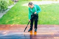 Power washing - man cleaning terrace with a power washer - high water pressure cleaner on terrace surface