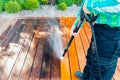 Power washing - man cleaning terrace with a power washer - high water pressure cleaner on terrace surface