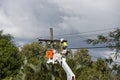 Power worker in a bucket truck with electricity wires.