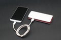 Powerbank charging smartphone on dark background Royalty Free Stock Photo