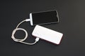 Powerbank charging smartphone on dark background Royalty Free Stock Photo