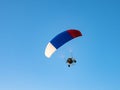 Powered parachute against the blue sky.