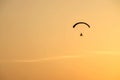 Powered paraglider flying away with sunrise