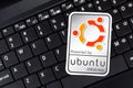 Powered by Ubuntu GNU Linux operating system sticker, logo symbol label closeup, laptop keyboard. Debian open source software