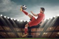 Powerful asian footballer kick the ball in the air Royalty Free Stock Photo