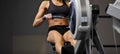 Powerful attractive muscular woman CrossFit trainer do workout on indoor rower at the gym Royalty Free Stock Photo
