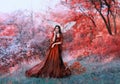 Powerful autumn nymph, queen of fire and goddess of hot sun, lady in long red light dress with loose sleeves with dark Royalty Free Stock Photo