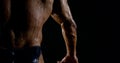 The powerful back of a brutal muscular bald male bodybuilder close-up on a black background, he is in the rain, water Royalty Free Stock Photo