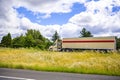 Powerful beige day cab big rig semi truck transporting cargo in dry van semi trailer driving on the highway exit road on the Royalty Free Stock Photo