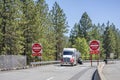 Powerful big rig semi truck transporting liquid cargo in tank semi trailer running from highway road to rest area entrance Royalty Free Stock Photo