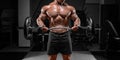 Powerful bodybuilder trains in a gym with a barbell. No name portrait. Bodybuilding concept