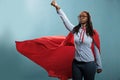 Powerful and brave young superhero woman wearing hero costume while posing as flying