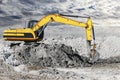 A powerful caterpillar excavator digs the ground against the evening sunset. Earthworks with heavy equipment at the construction Royalty Free Stock Photo