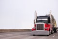 Powerful classic black and red big rig semi truck transporting r Royalty Free Stock Photo