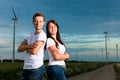 Powerful couple in front of windmill in the evenin Royalty Free Stock Photo