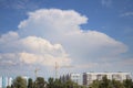 Powerful Clouds in Sky Over Cranes and Houses Royalty Free Stock Photo