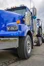 Blue big rig semi truck towing another semi truck tractor on the chassis frame