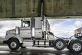 Powerful day cab white big rig semi truck tractor with semi trailer with oversize load sign running on the transportation two Royalty Free Stock Photo