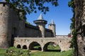 Powerful fortifications and bastions of Carcassonne Castle. Beautiful conical blue roofs of towers. Bridge and entrance to the