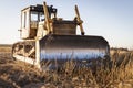 Powerful heavy crawler bulldozer works at a construction site in the evening against the background of the sky. Construction Royalty Free Stock Photo