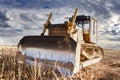 Powerful heavy crawler bulldozer works at a construction site in the evening against the background of the sky. Construction Royalty Free Stock Photo