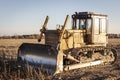 Powerful heavy crawler bulldozer works at a construction site in the evening against the background of the sunset sky. Royalty Free Stock Photo