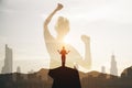 A powerful image of a female silhouette flexing her muscles against a vibrant city sunset, symbolizing strength Royalty Free Stock Photo