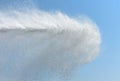 Powerful jet of water from the fire hose of the car against the background of the blue sky Royalty Free Stock Photo