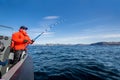 powerful man with a spinning rod in his hands. sea boat. fisherman