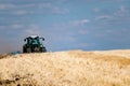 Powerful modern machine for harvesting from the field.  Golden field of ears, barley, wheat and rye, harvesting equipment against Royalty Free Stock Photo