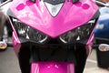 Powerful modern pink bright sport motorcycle, front view.
