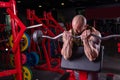 Powerful muscular man doing biceps exercise with barbell on the bench Royalty Free Stock Photo