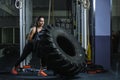 Powerful muscular woman CrossFit trainer doing tire workout at gym Royalty Free Stock Photo