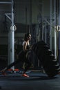 Powerful muscular woman CrossFit trainer doing tire workout at gym Royalty Free Stock Photo