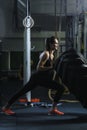 Powerful muscular woman CrossFit trainer doing tire workout at gym Royalty Free Stock Photo