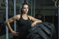 Powerful muscular woman CrossFit trainer doing tire workout at gym Royalty Free Stock Photo