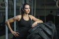 Powerful muscular woman CrossFit trainer doing tire workout at gym Royalty Free Stock Photo