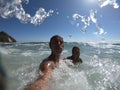 Powerful ocean waves splashing funny couple