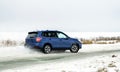 Powerful offroader car sliding by lake ice