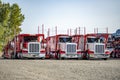 Powerful professional classic big rigs car hauler semi trucks with modular semi trailers standing in row on the business parking Royalty Free Stock Photo