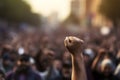 Powerful protest hand clenched in a fist against blurred crowd