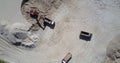 Excavator fills tipper with ore at sand quarry aerial view