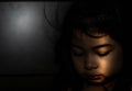 Powerful shot of a sad asian child. Female asian child sad dark scene